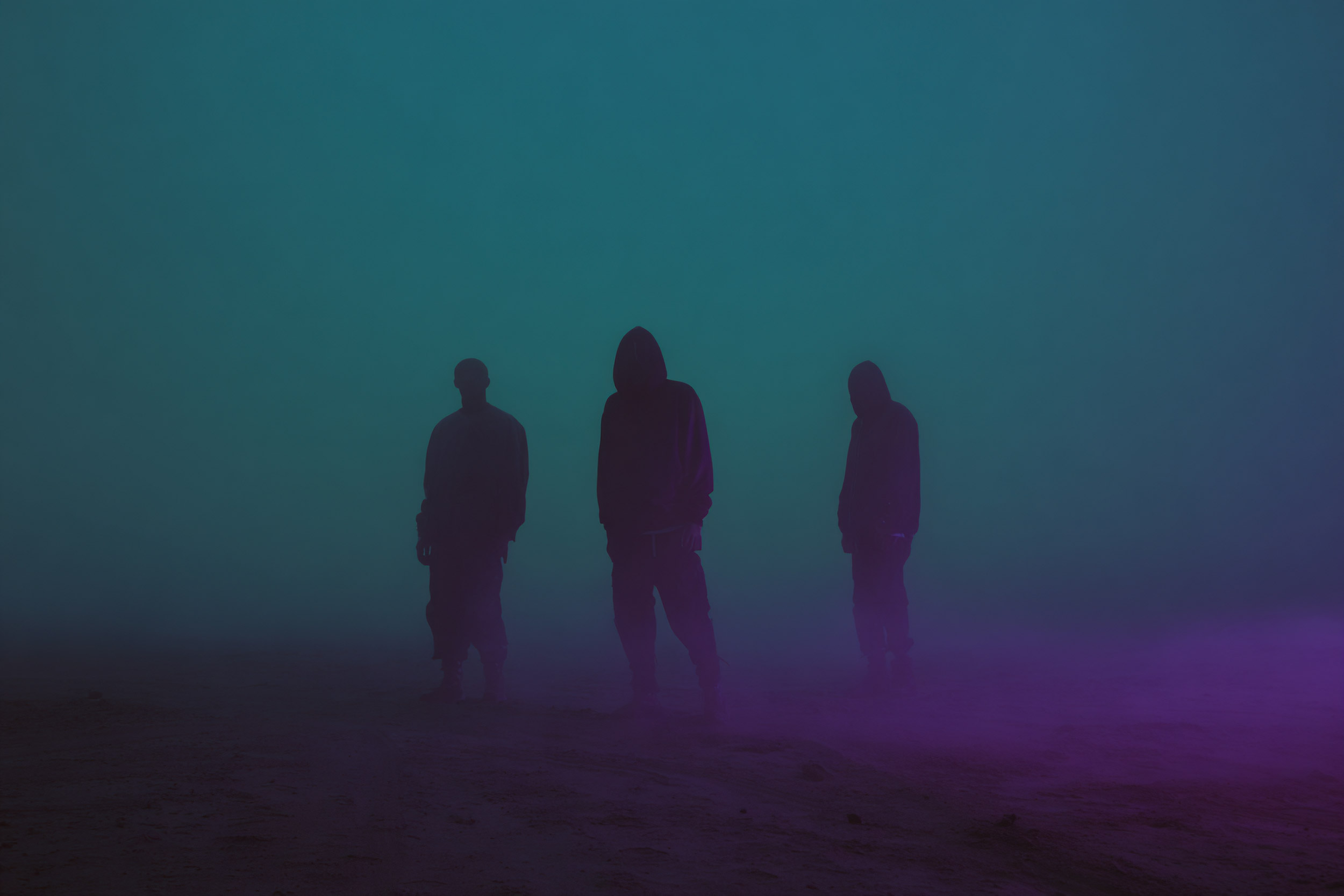 Three shadowed figures standing in neon mist — Bleed Electric band photo.